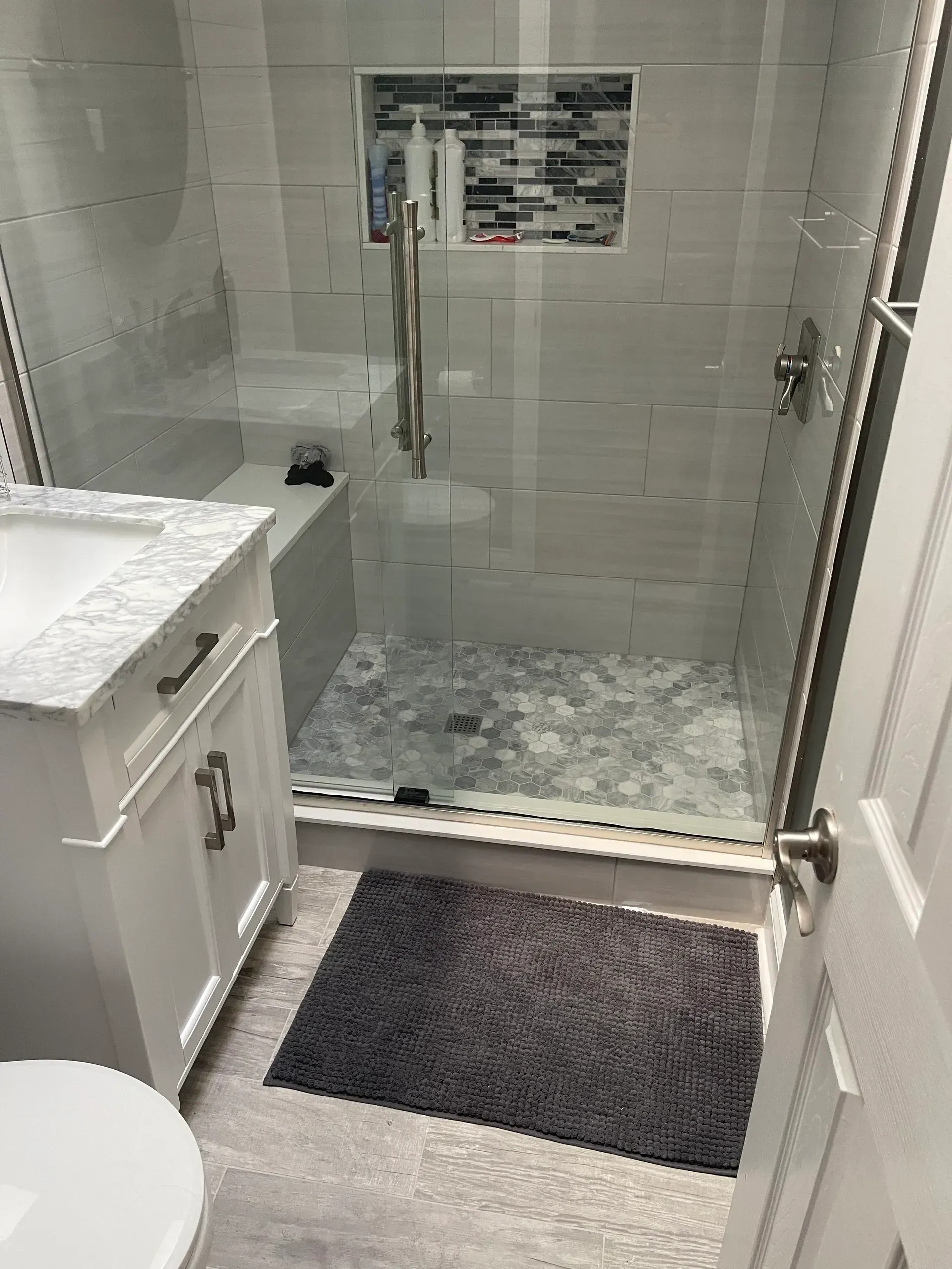 Modern bathroom with shower, vanity, and toilet. 