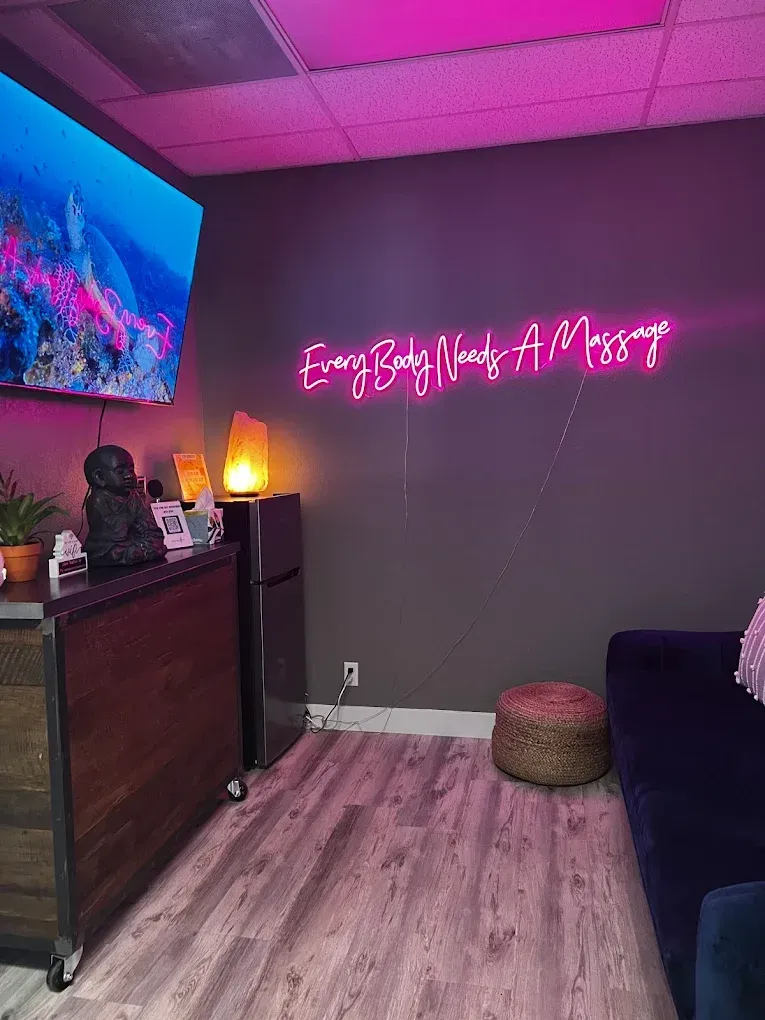 Massage room with neon sign that reads 