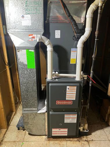 HVAC furnace and ductwork in a utility closet with insulated pipes and green inspection tags