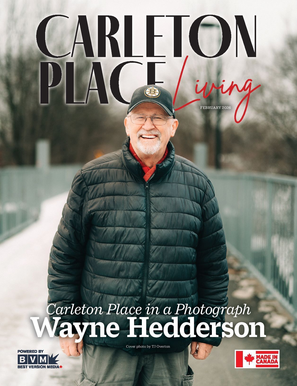 Wayne Hedderson standing on a bridge, wearing a black jacket and cap, for Carleton Place Living cover.
