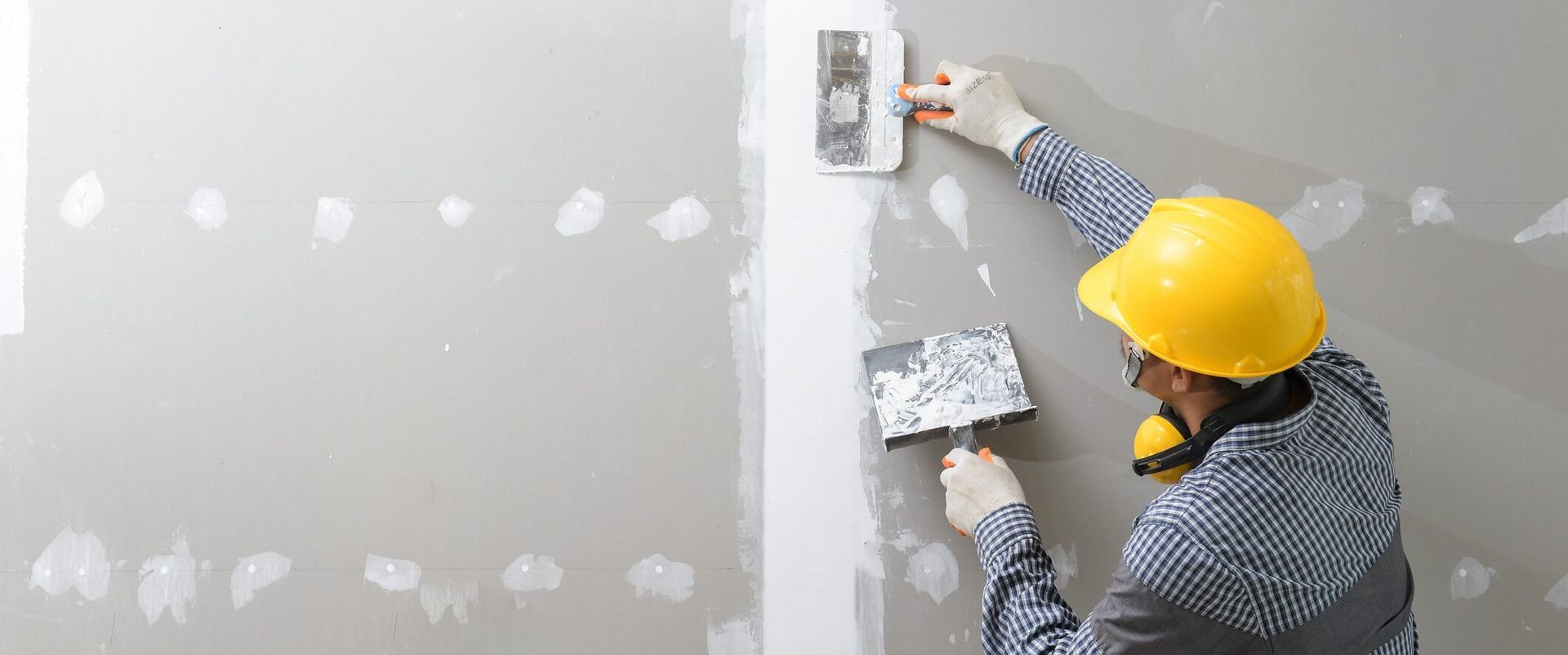 Contractor finishing drywall after a full sheetrock installation