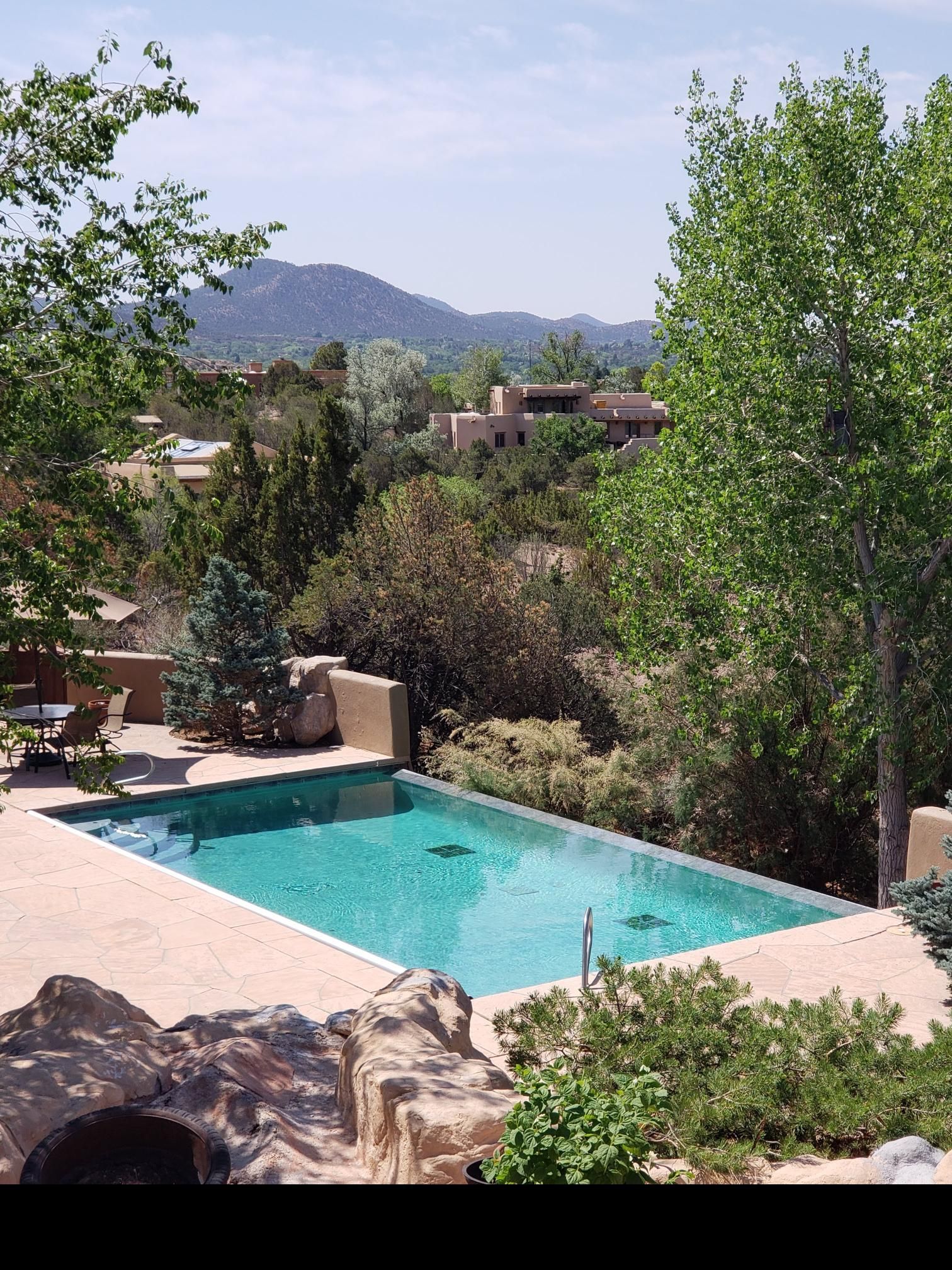 A Large Swimming Pool is Surrounded by Trees and Mountains