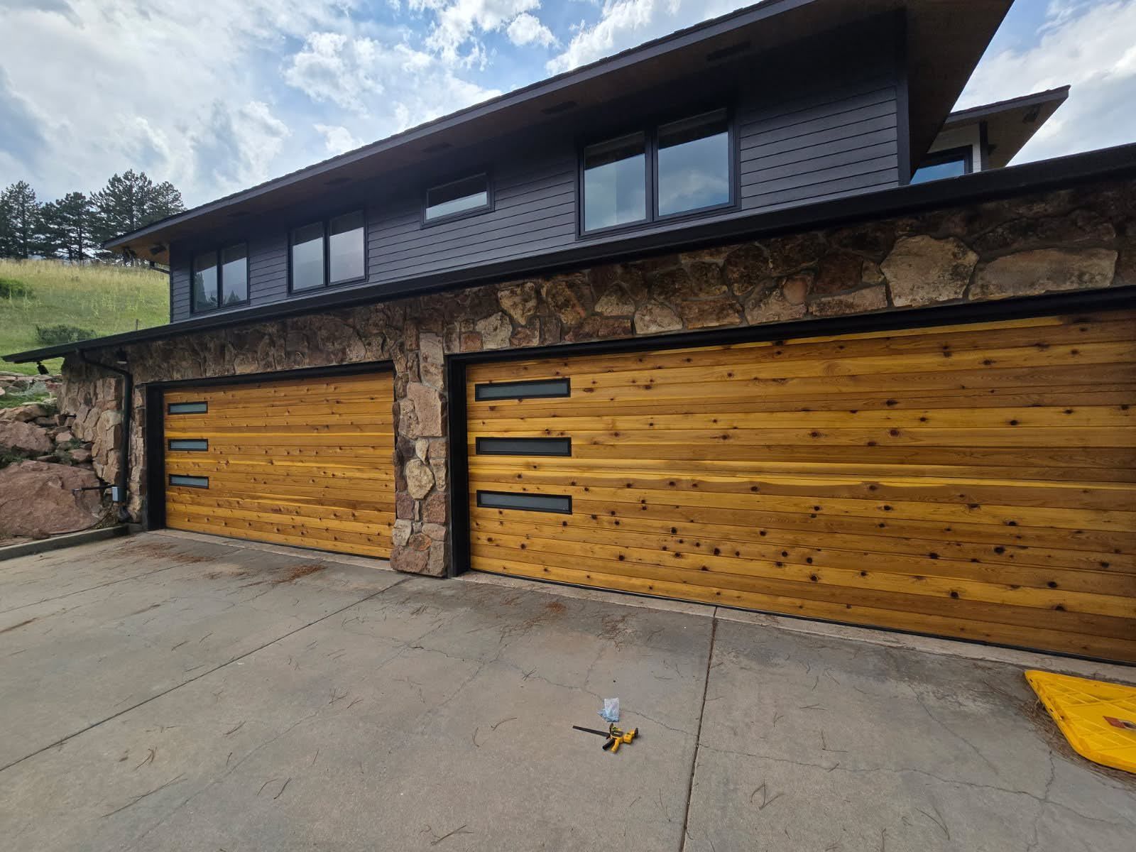Modern house with two wooden garage doors and a concrete driveway