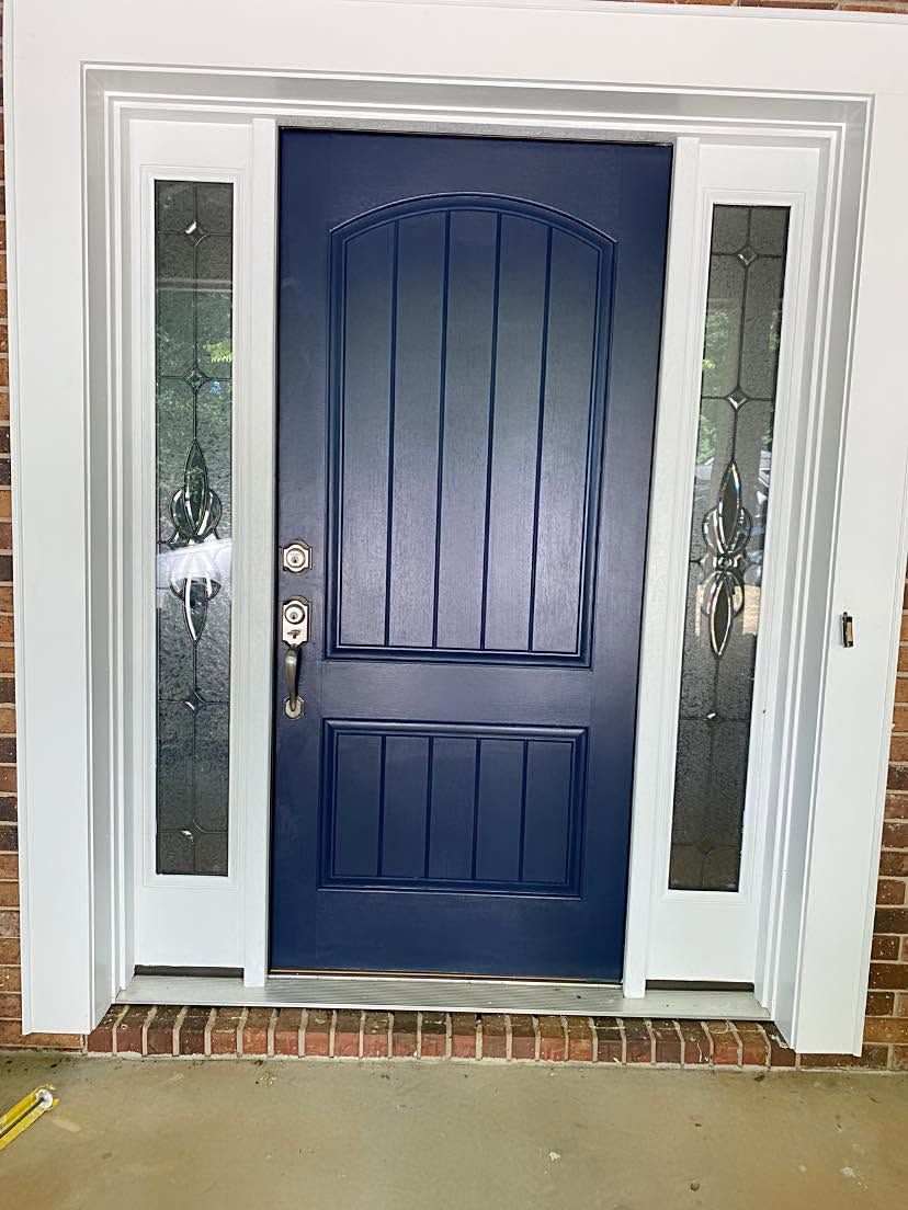 Blue front door with sidelights in a white trim entryway