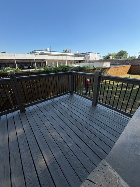 Wooden deck overlooking a landscaped courtyard under a clear blue sky