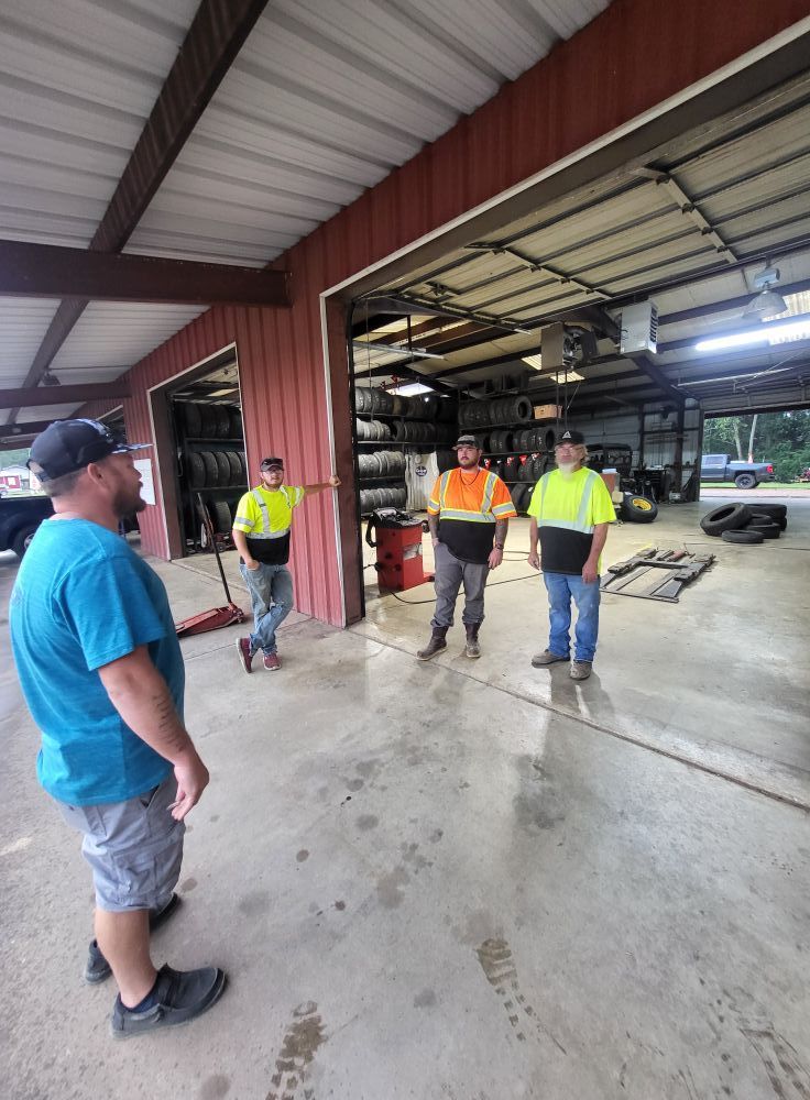 Workers in safety vests discussing inside a metal warehouse bay