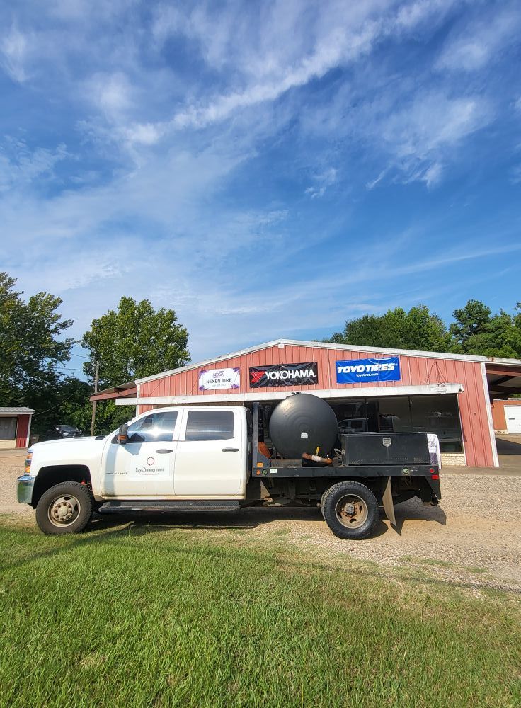 White pickup truck parked in front of a red building under a blue sky