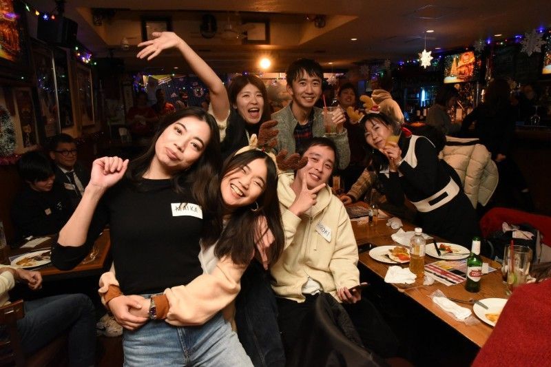 一群の人々がレストランで写真のポーズをとっています。