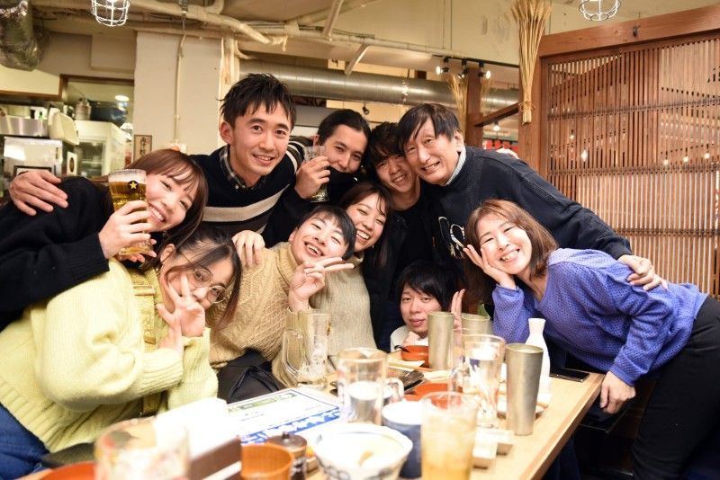 一群の人々がレストランで写真のポーズをとっています。