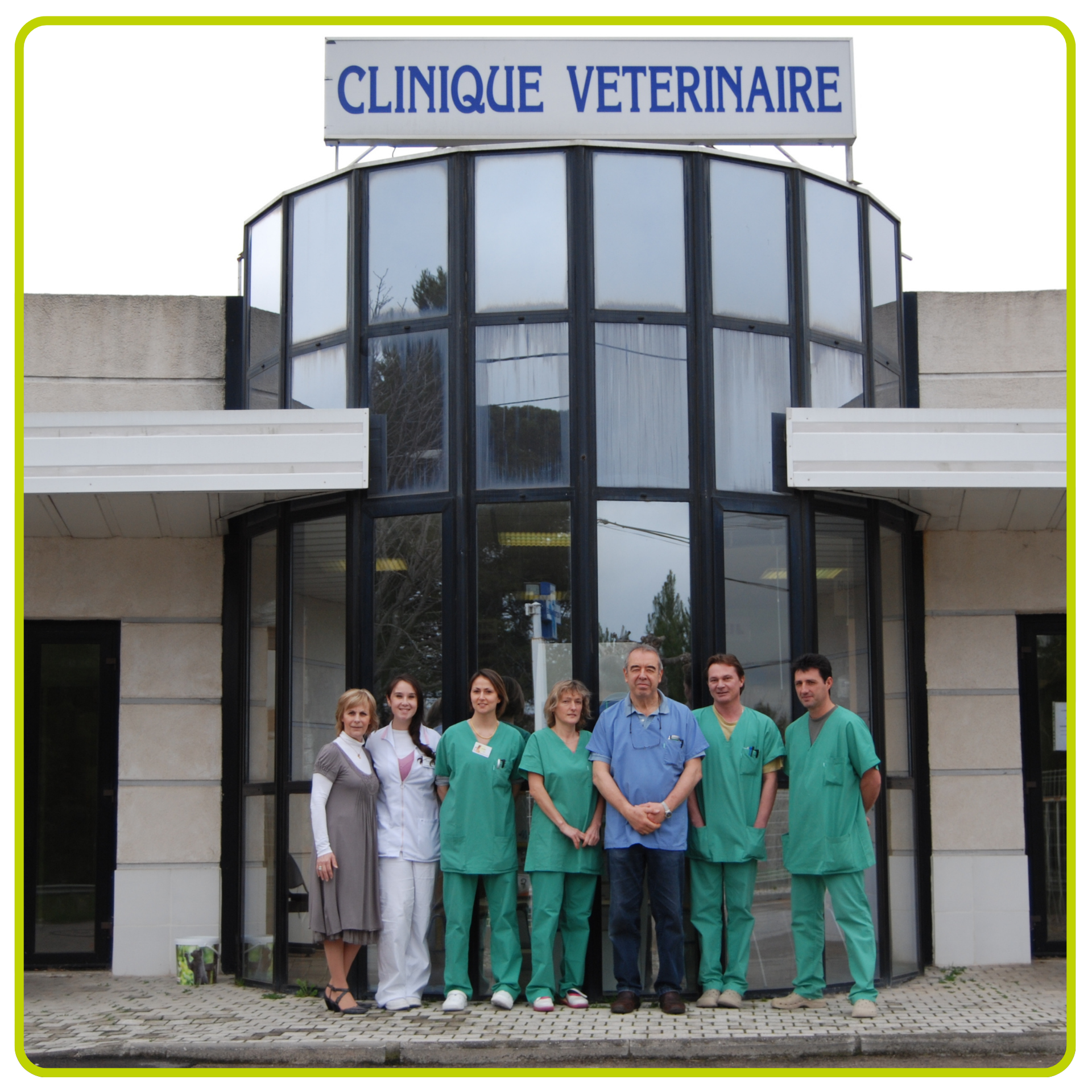 Le personnel d'une clinique vétérinaire pose devant l'entrée de la clinique sous un panneau « CLINIQUE VÉTÉRINAIRE ».