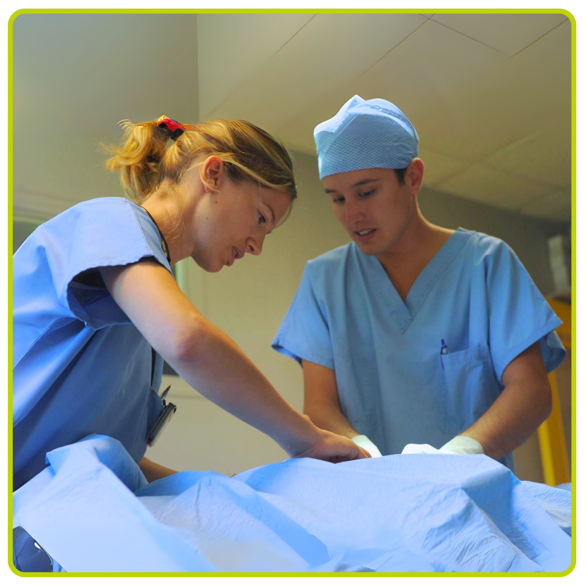 Deux membres du personnel médical en blouse bleue s'occupent d'un patient sous des draps blancs dans une chambre d'hôpital
