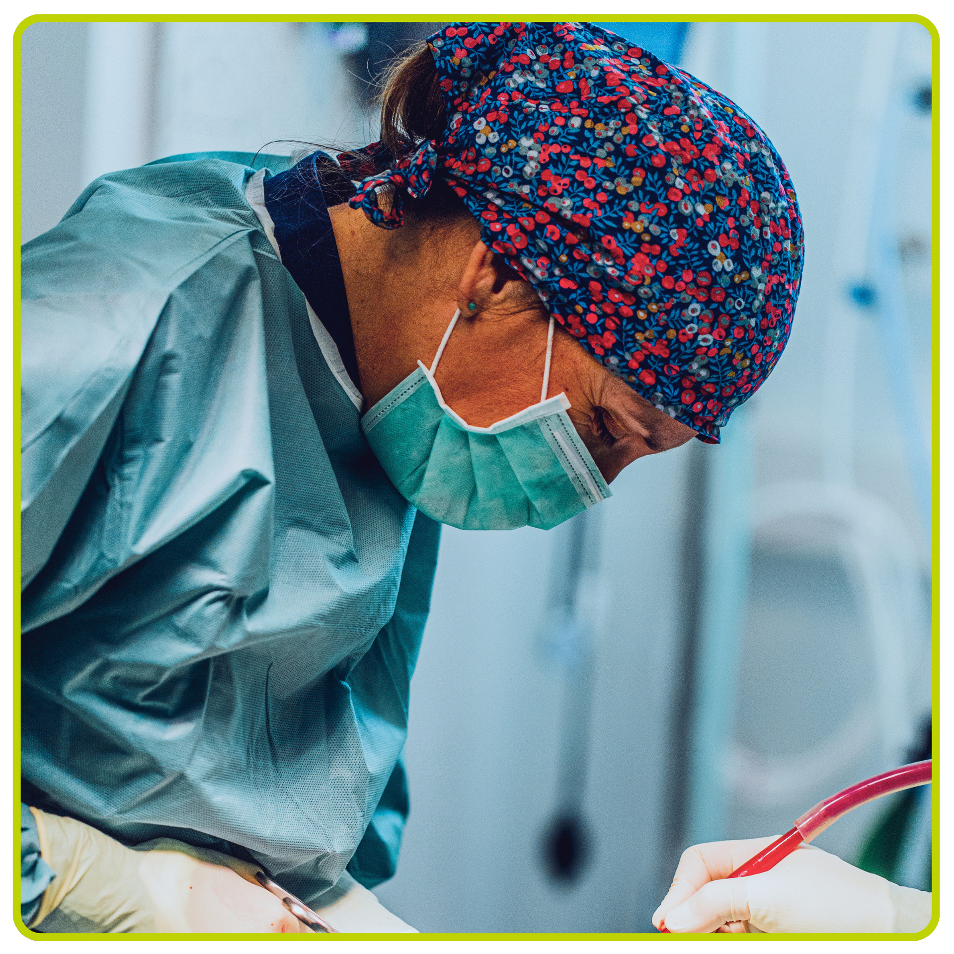 Un clinicien masqué, vêtu d'une blouse chirurgicale, se penche sur un patient dans un environnement hospitalier.