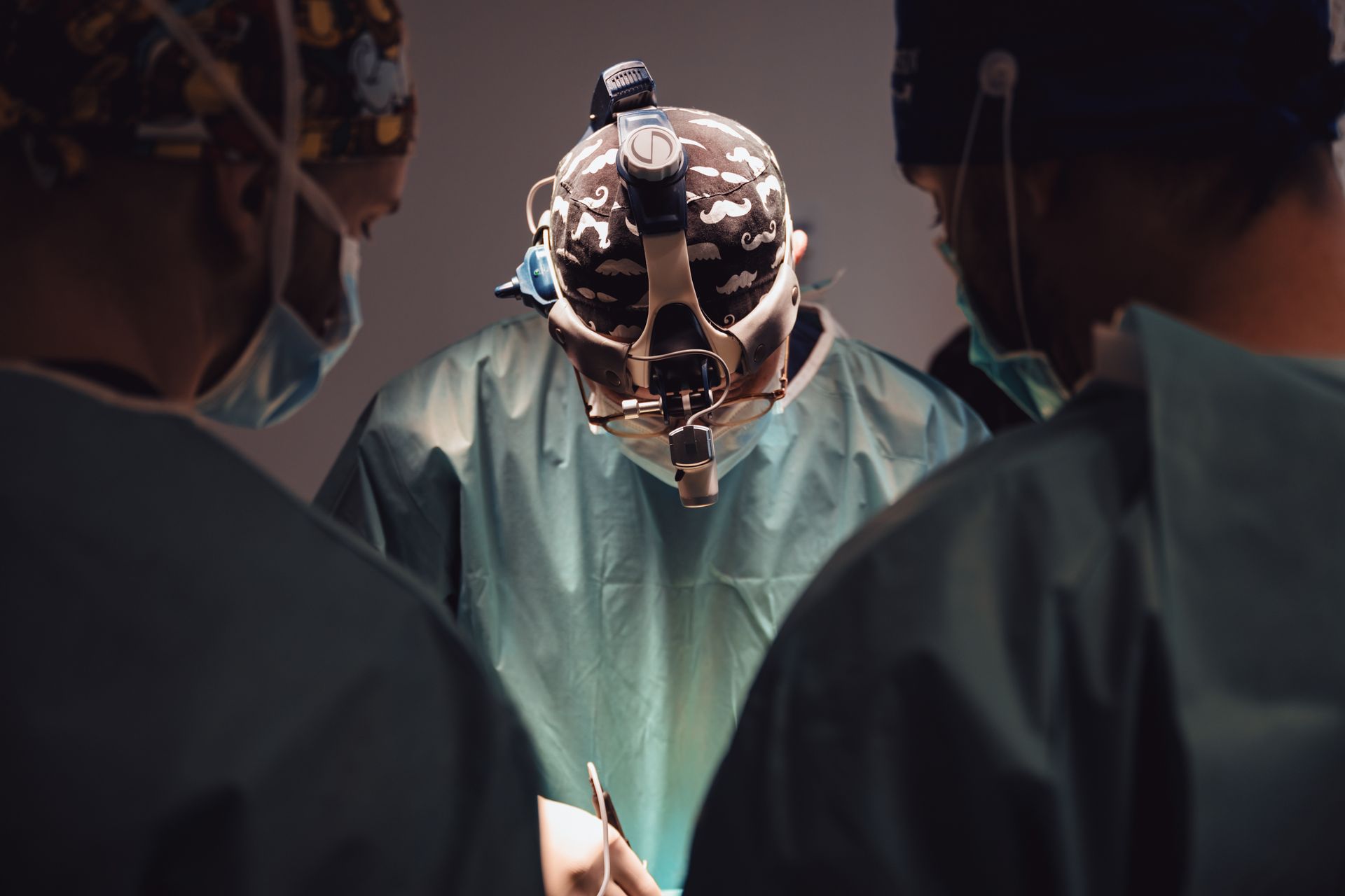 Des chirurgiens en blouse blanche entourent un robot chirurgical allumé dans une salle d'opération