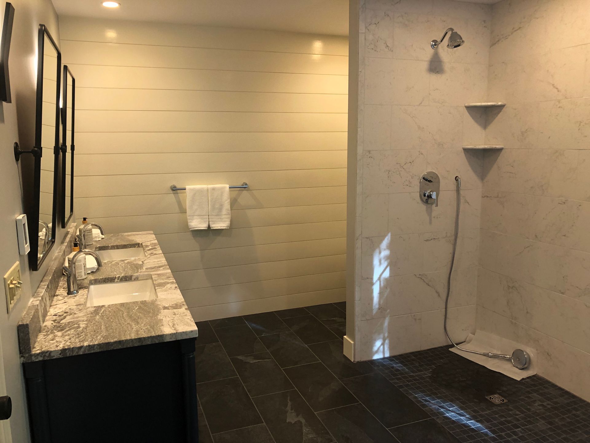 Modern bathroom with double vanity, toilet, and tiled shower area under renovation