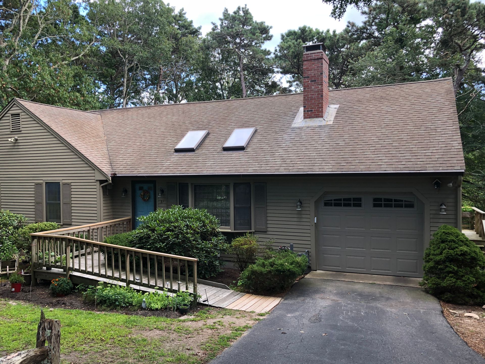 Suburban house with a garage, front ramp, and two skylights on the roof