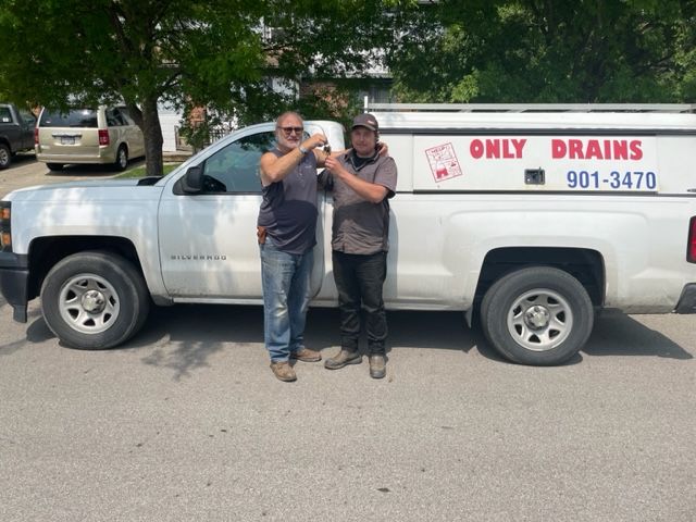 Two men standing by a white 