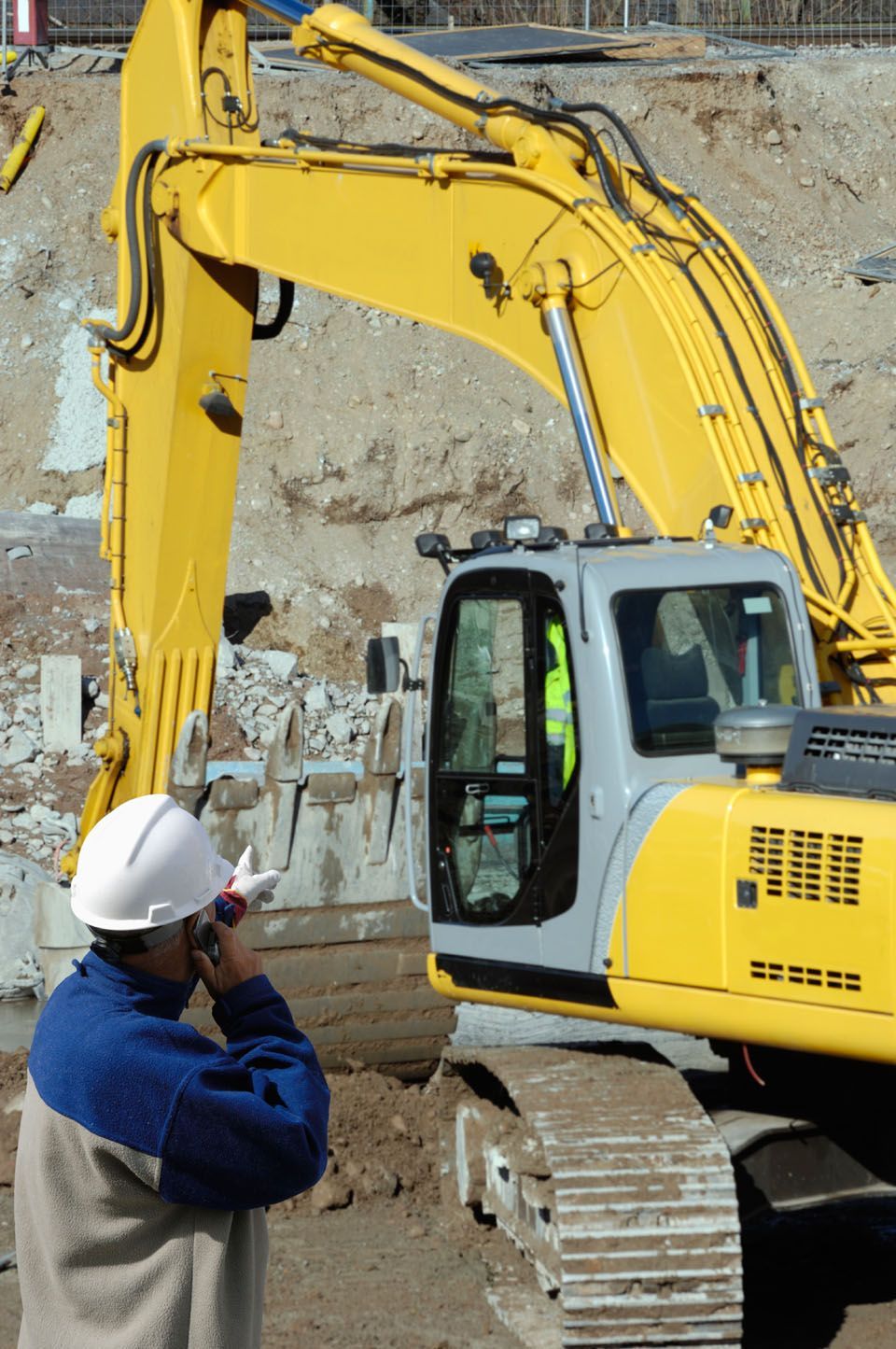 A man pointing on a construction site with a JCB digger