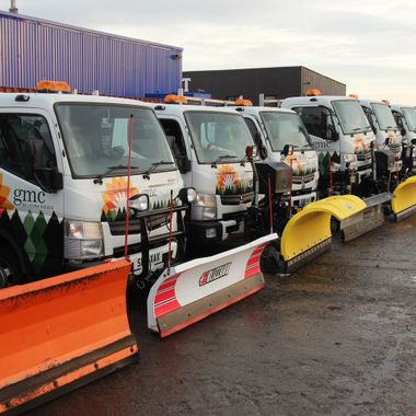 Row of trucks with ploughs