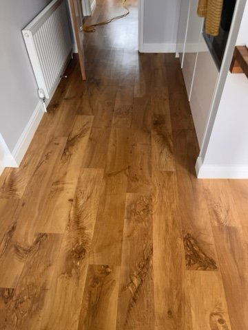 A hallway with a wooden floor and a radiator.