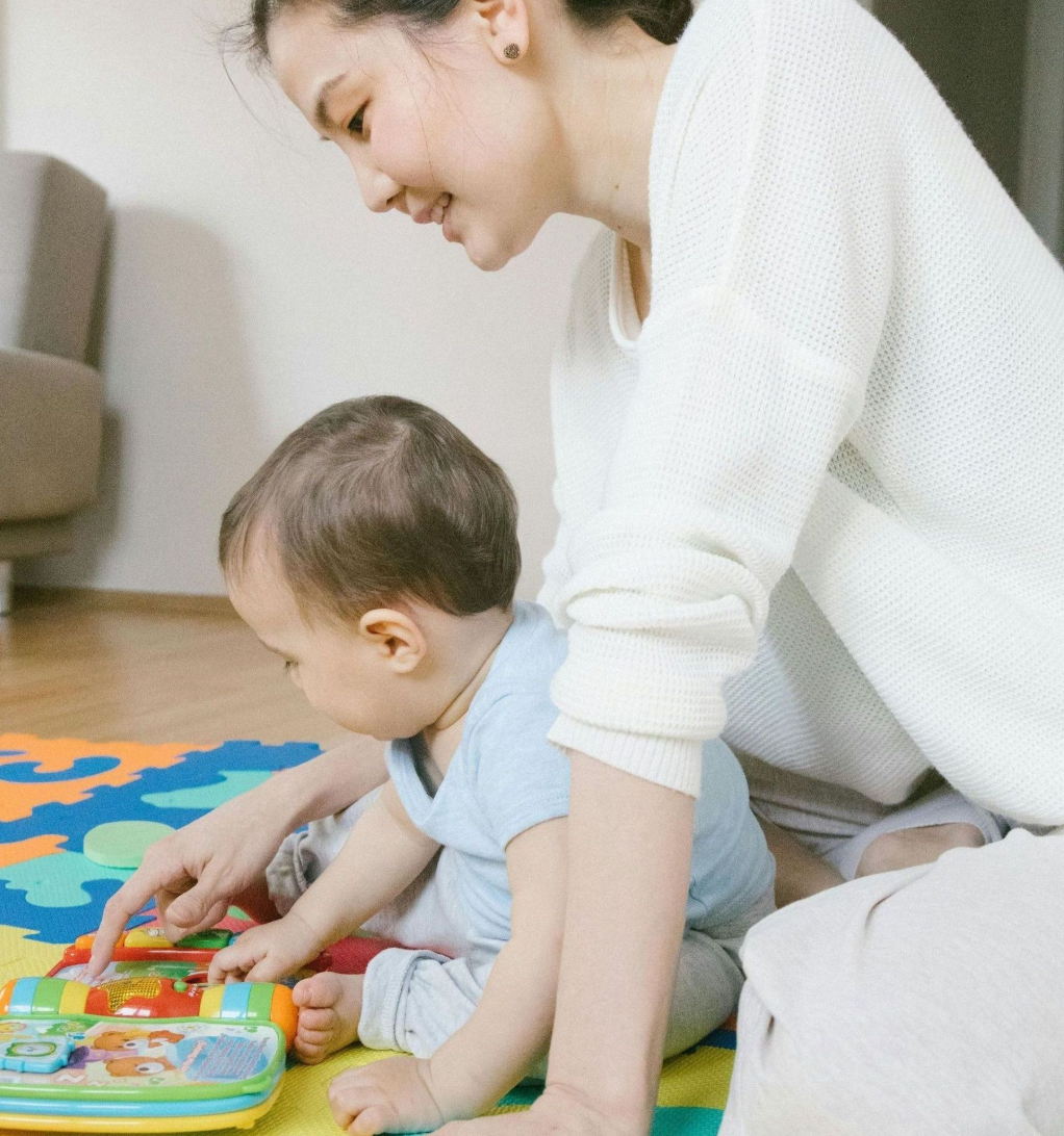 A woman and child are playing with blocks on the floor