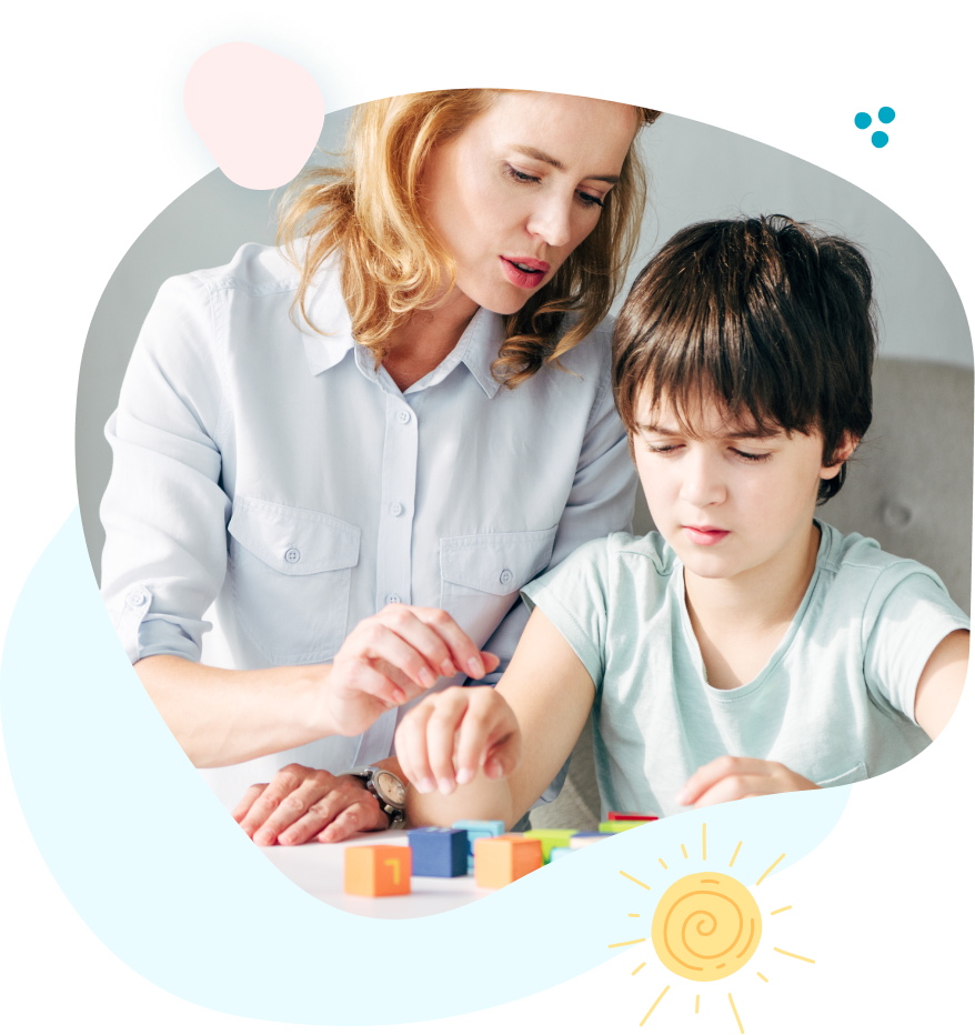 A woman is teaching a young boy how to play with blocks.
