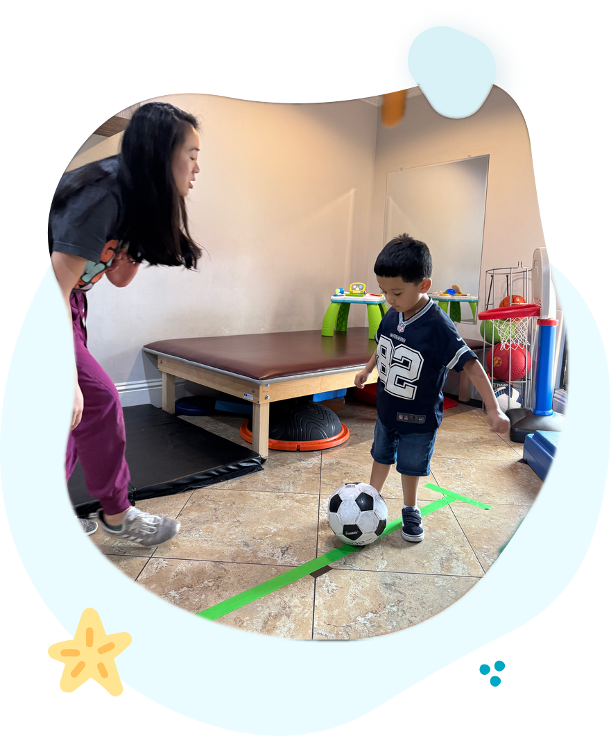 Physical therapist working with a child on soccer ball coordination exercises
