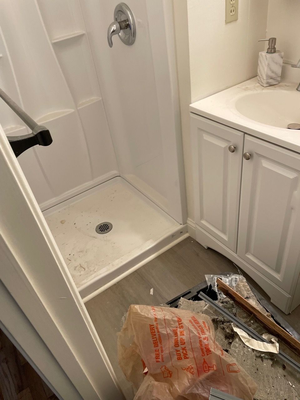 Bathroom with shower stall, sink cabinet, and cardboard boxes on the floor.