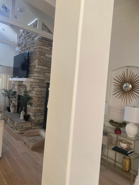 Living room with TV, brick fireplace, and gold sunburst wall decor