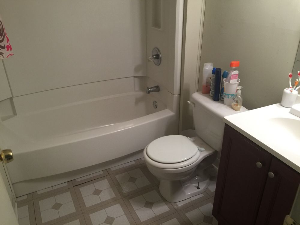 Small bathroom with tub, toilet, sink, and vanity.