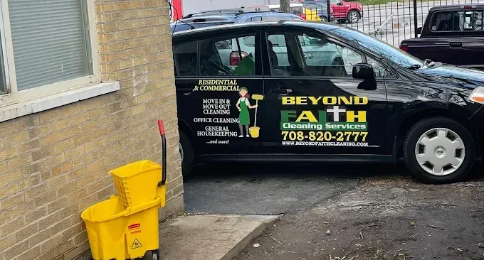 Black Beyond Faith company van parked beside a building, with yellow trash bins in the foreground.