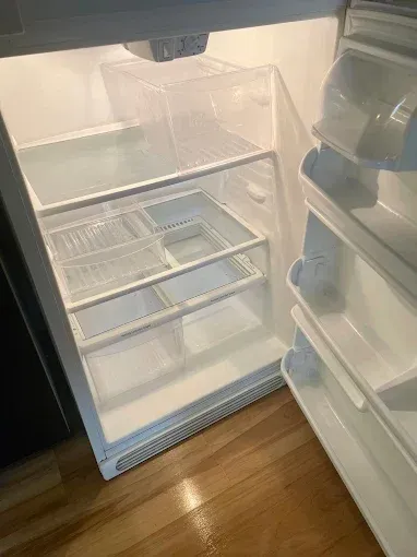 Open refrigerator with mostly empty shelves and a few items in the door bins.