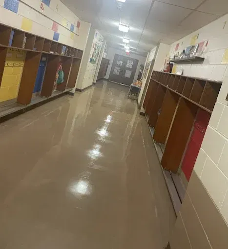 Empty school hallway with lockers and a shiny brown floor