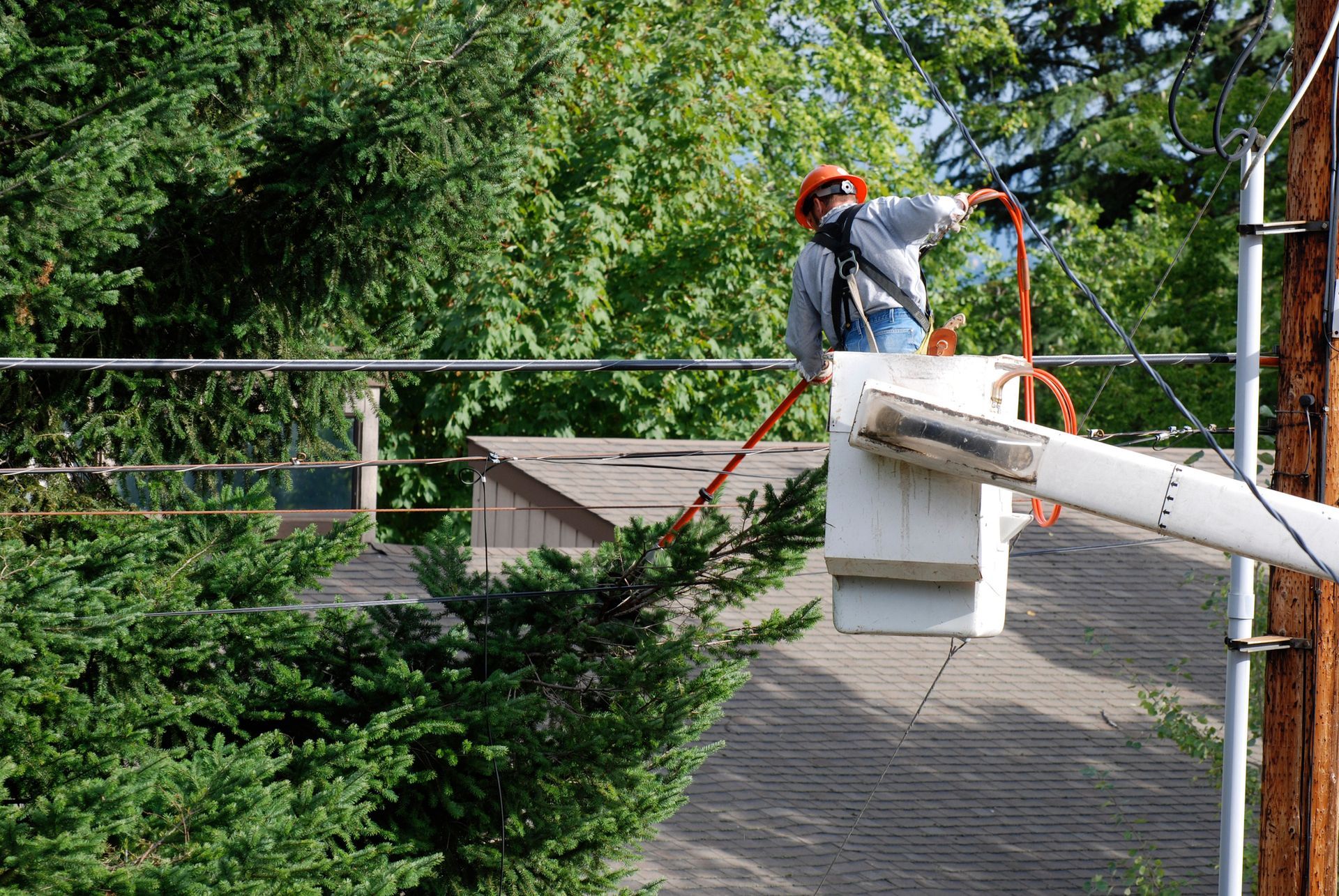 A man in a bucket is working on a power line