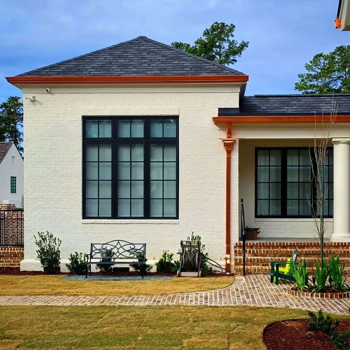 A white brick house with a black window
