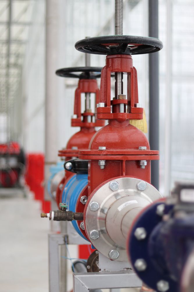 A Row of Red Valves Sitting Next to Each Other in a Factory — Dave's Plumbing and Gasfitting in Maroochydore, QLD