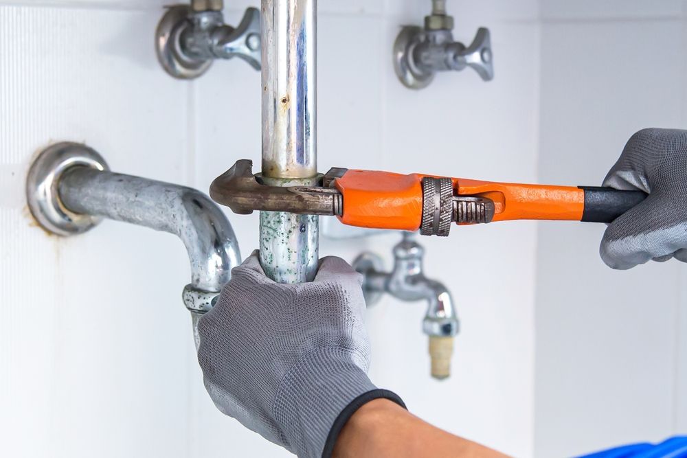A Plumber is Fixing a Sink Pipe With a Wrench — Dave's Plumbing and Gasfitting in Maroochydore, QLD