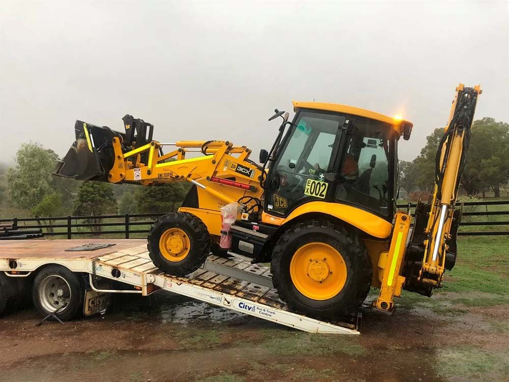 Bulldozer Driving onto the Flatbed Truck — Verification of Competency Mid North Coast