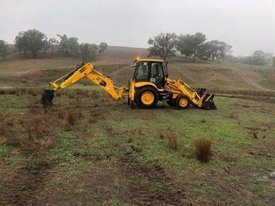 Yellow excavator in an Open Field — Plant Operator Courses Mid North Coast