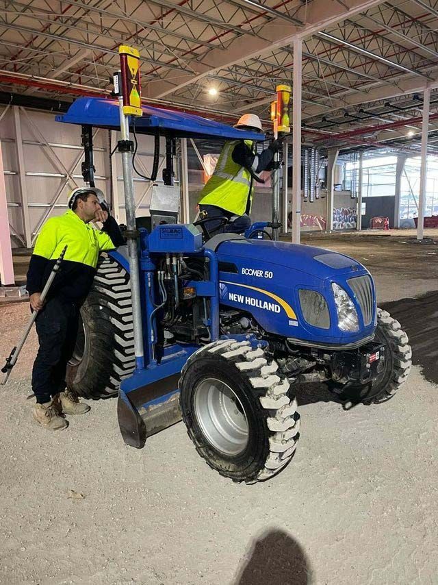  Two men standing near a blue tractor — Plant Operator Courses Near Me In Australia