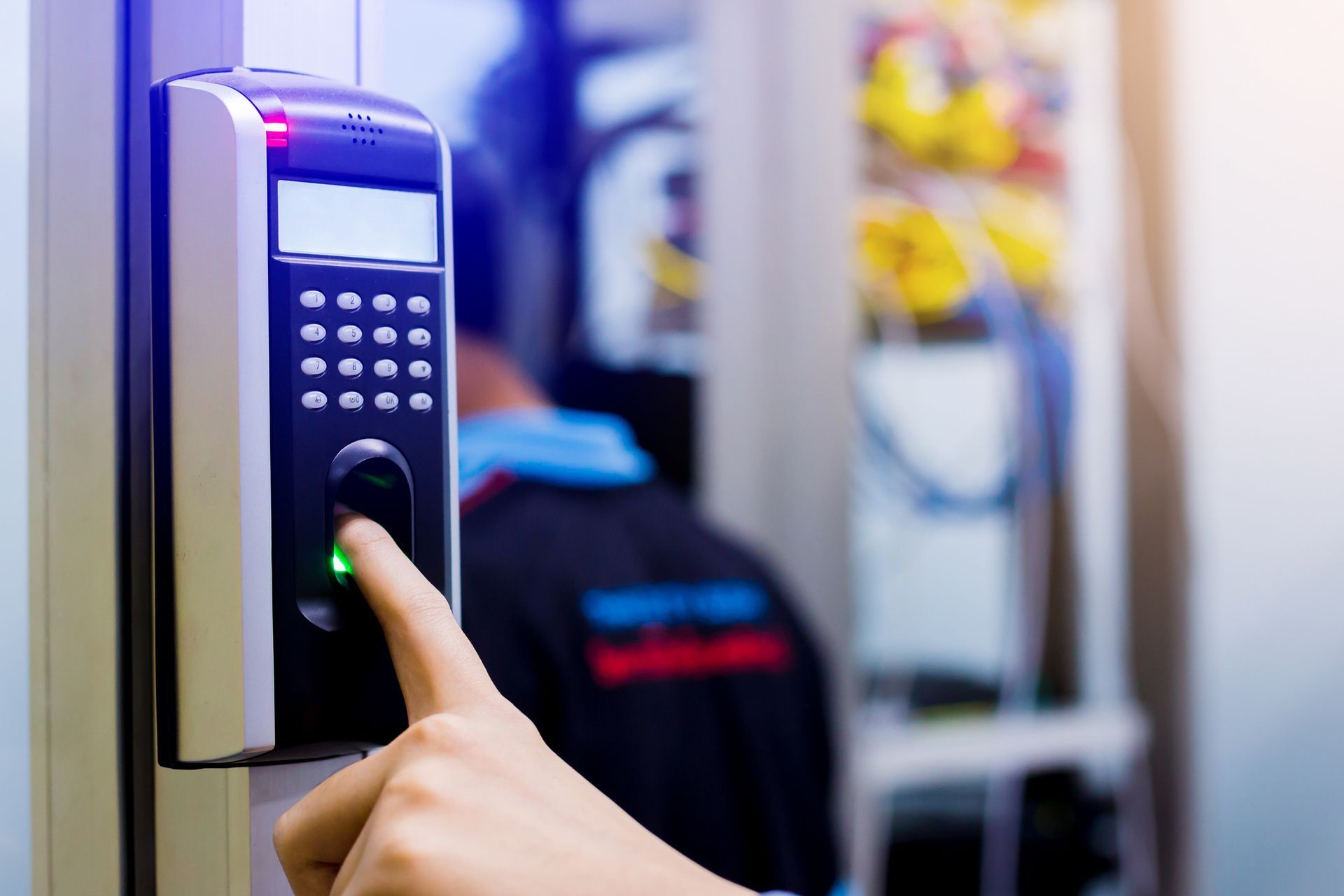 Hand pressing a button on an electronic access control device.