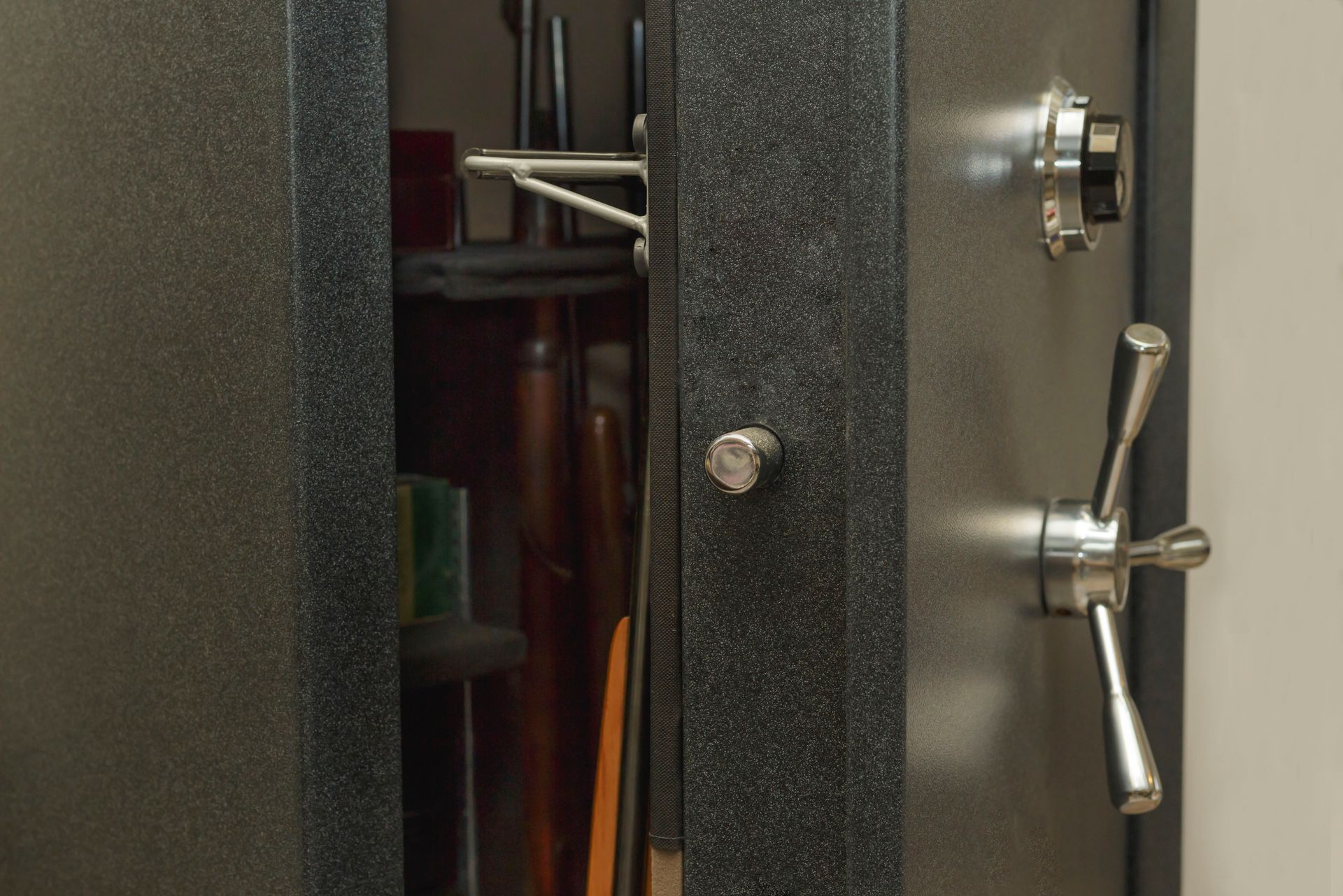 A safe is sitting on a shelf in a closet.