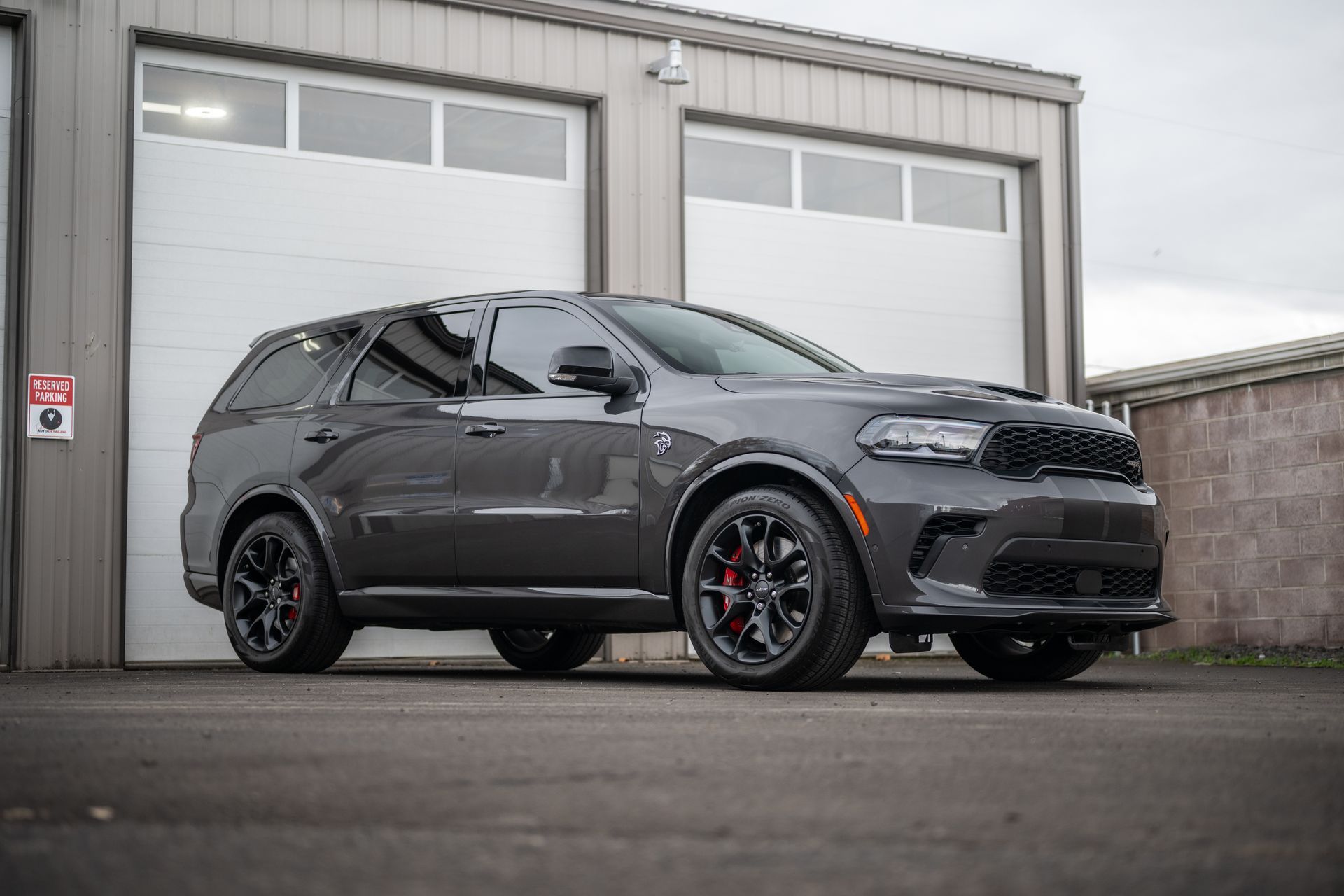 Dark gray Dodge Durango SUV parked outside garage doors on an industrial lot