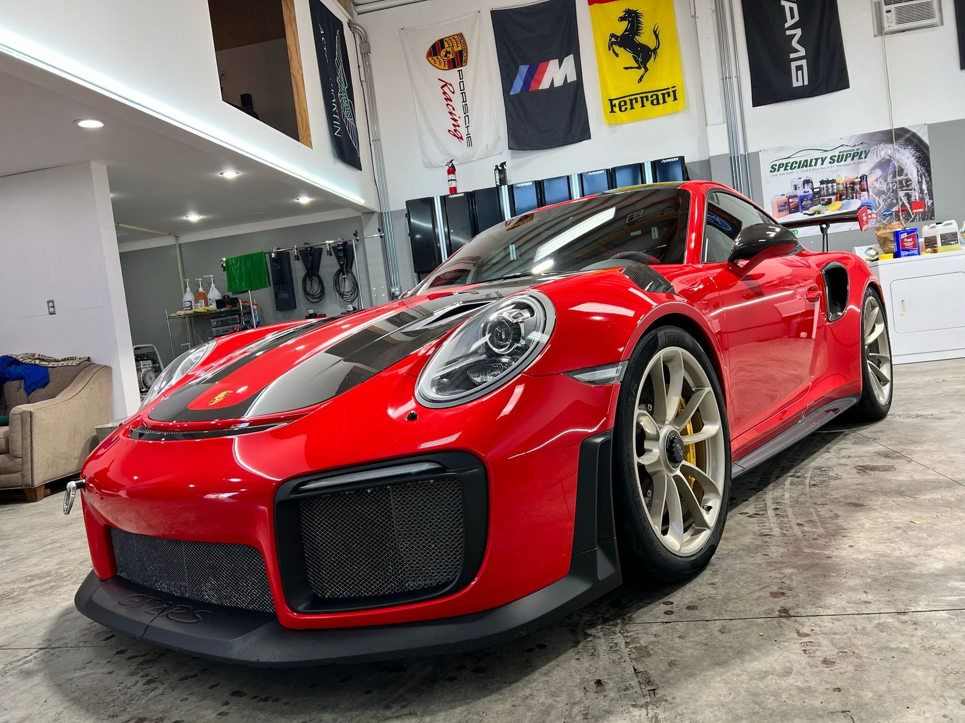 A red porsche 911 gt2 rs is parked in a garage.