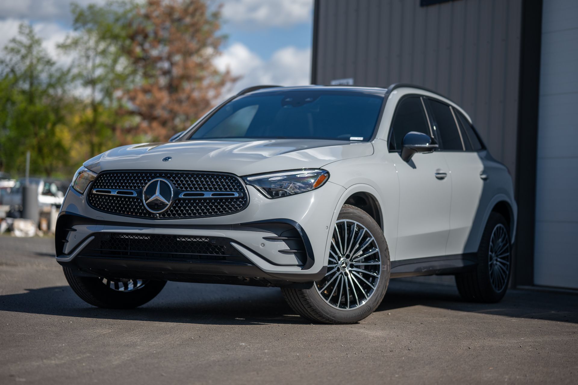 White Mercedes-Benz SUV parked outdoors beside a building on a sunny day
