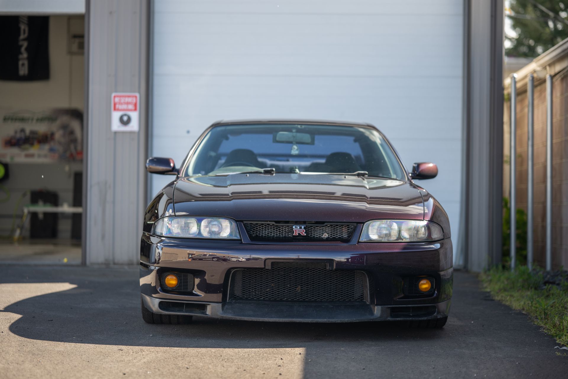 Front view of a dark sedan parked in a garage entrance