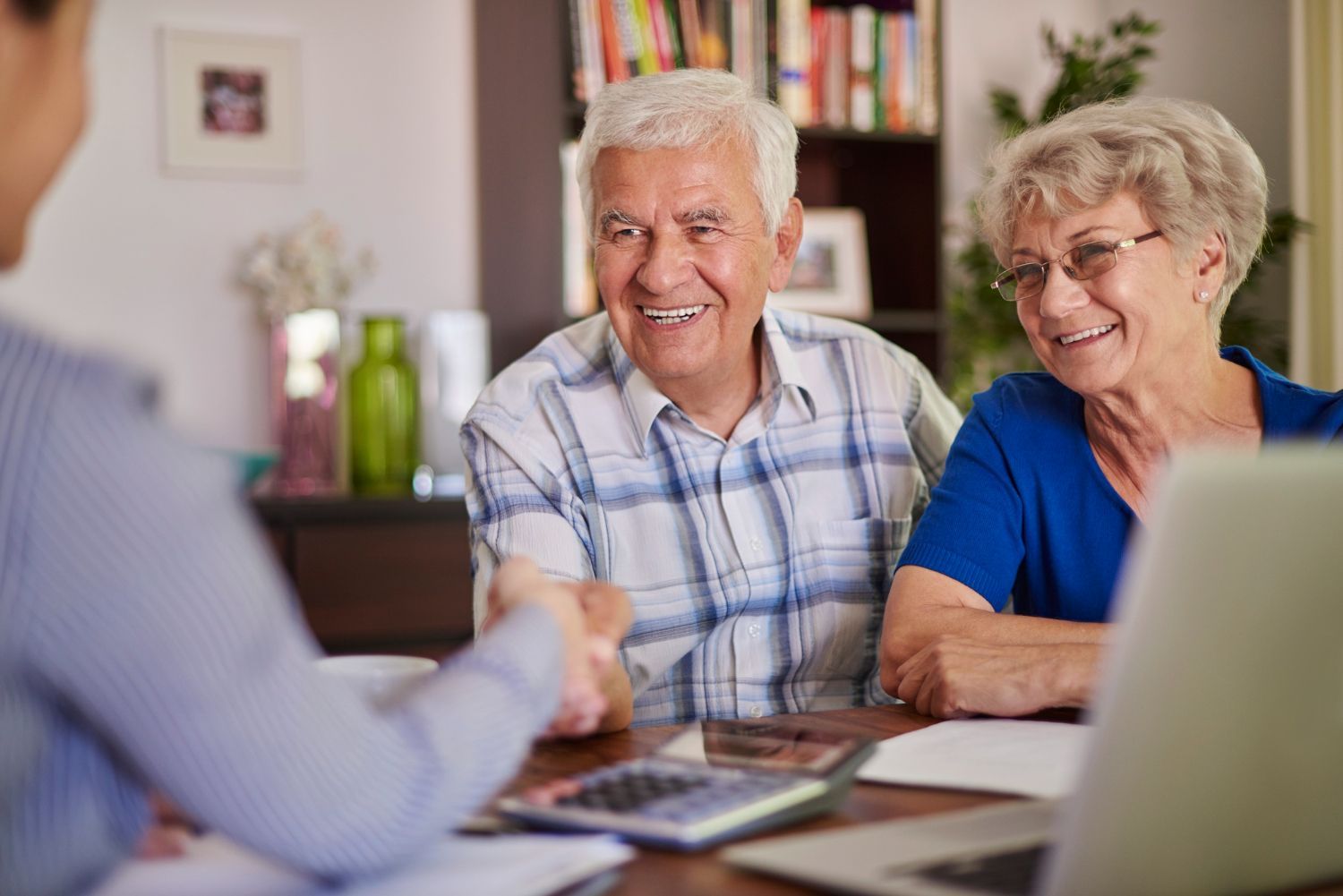 Smiling couple talking with a financial advisor at a table in a bright office