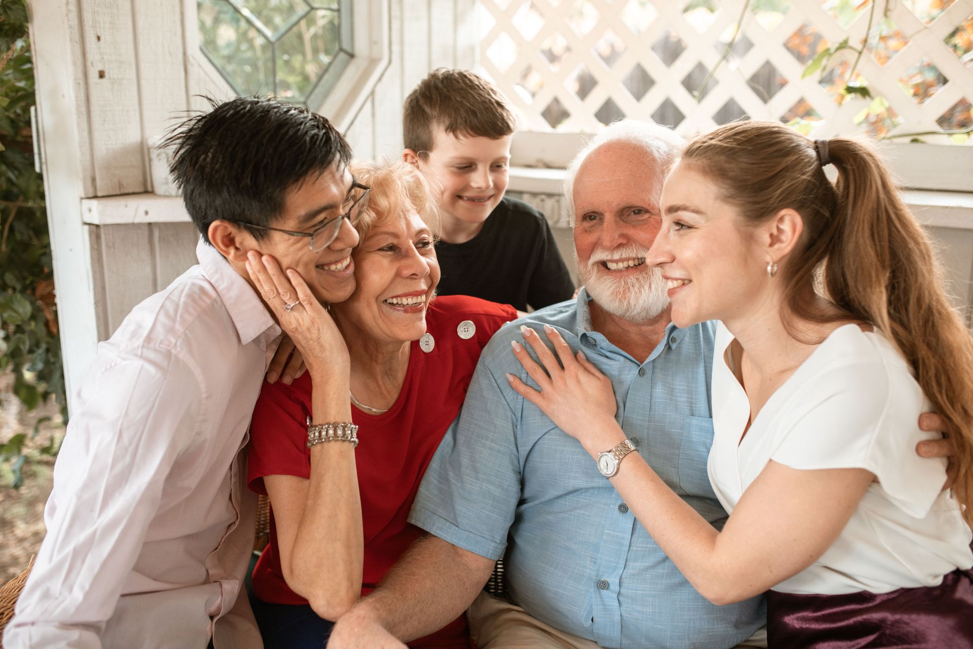 Smiling group of five embracing indoors in a bright home setting