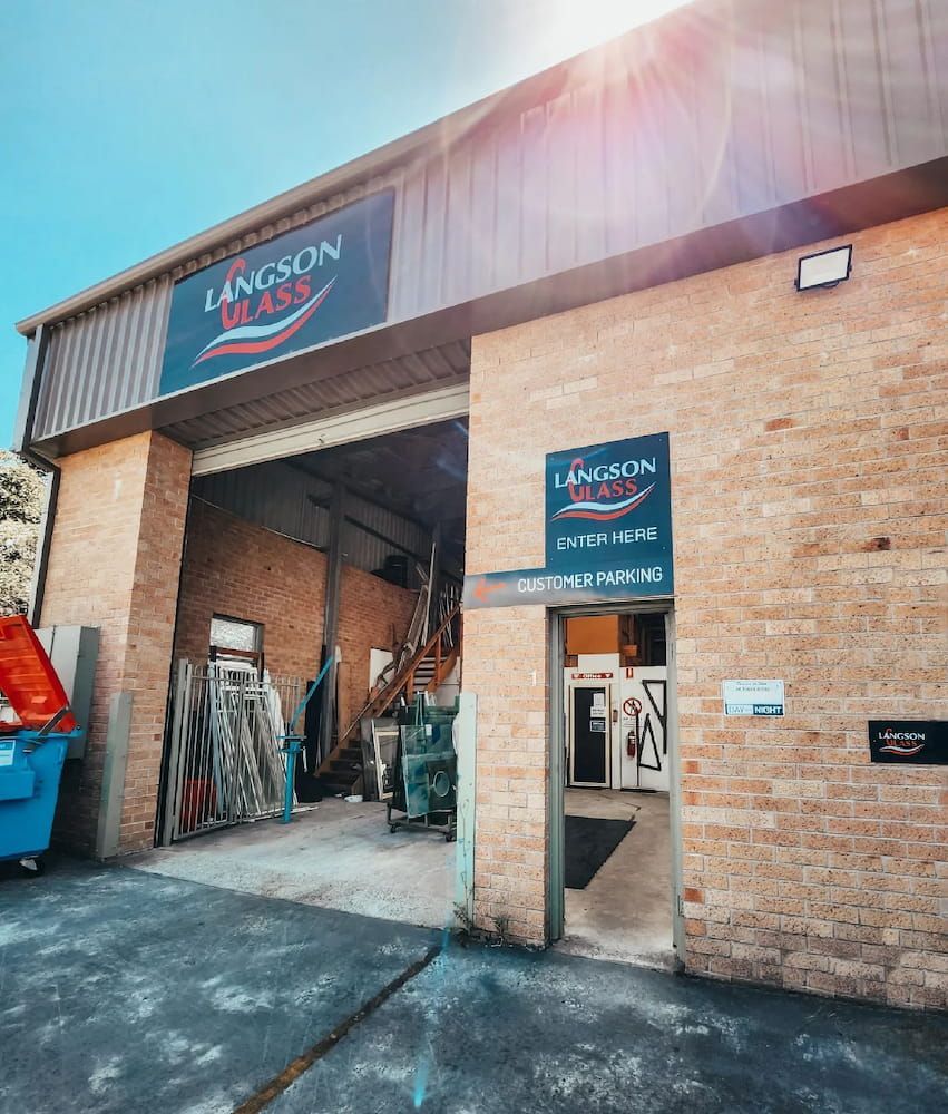 A Large Brick Building With a Sign That Says Langron Brass — Langson Glass in Wollongong, NSW 
