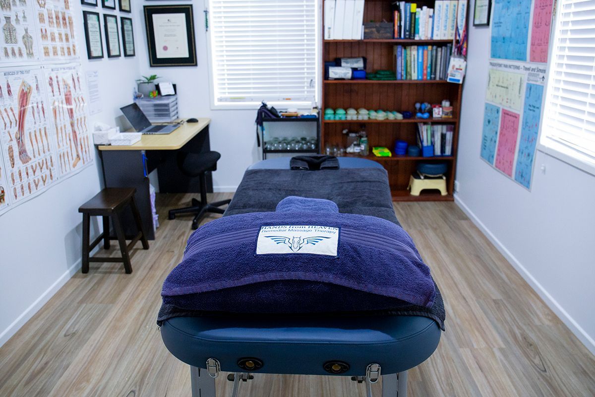 A Massage Table In A Room With A Purple Towel On It – Chermside, QLD - Hands From Heaven Remedial Therapy Clinic