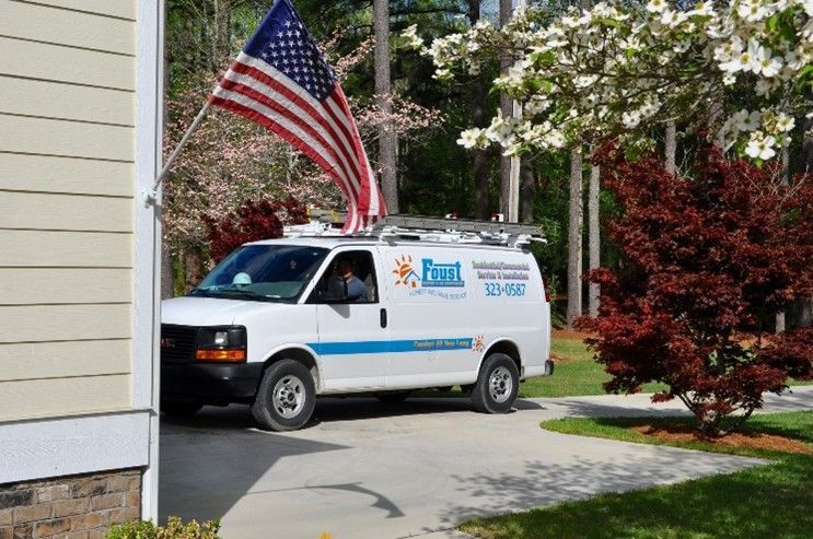 White service van with American flag parked in driveway.